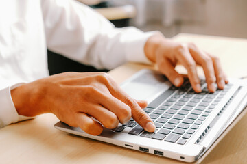 Wall Mural - Businessman hand typing on computer keyboard of a laptop computer in office. Business and finance concept. uds