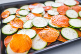 Fototapeta  - zucchini and sweet potato slices on oven tray with seasoning