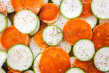 Fototapeta  - zucchini and sweet potato slices on oven tray with seasoning