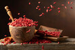 Dried goji berries in wooden bowl on a brown background.