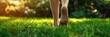 © leroy - Woman walking barefoot on green grass outdoor, close-up banner