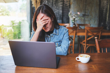 Canvas Print - A woman get headache and stressed while working online on laptop computer at home