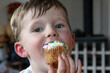 Little boy enjoys a delicious cupcake with colorful sprinkles