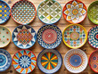 plates with beautiful patterns on wooden wall. different painted plates collection