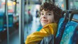 Smiling little boy riding bus looking away, beautiful boy taking bus to work, lifestyle concept. Young smiling man holding onto a handle while traveling by public bus.