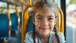 Smiling little girl riding bus looking away, beautiful  girl taking bus to work, lifestyle concept. Young smiling woman holding onto a handle while traveling by public bus.