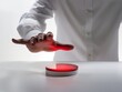 A person's hand hovering above a luminous red button, symbolizing urgency or initiation.