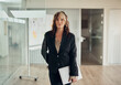 © Flamingo Images - Confident young businesswoman standing at the entrance to a boardroom