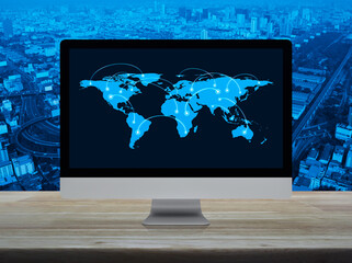 Wall Mural - Connection line with global world map on computer monitor screen on table over city tower, street, expressway and skyscraper, Technology communication online, Elements of this image furnished by NASA