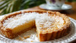 Close-up of a homemade jamaican coconut tart topped with grated coconut on a decorative plate, showcasing the flavors of caribbean cuisine