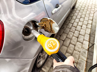 Fueling a Car at a Gas Station Pump. Vehicle being refueled with gasoline nozzle at a service station