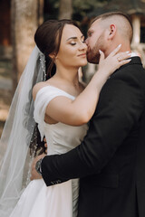 Wall Mural - A bride and groom are kissing each other's lips. The bride is wearing a white dress and the groom is wearing a black suit