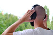 closeup young charismatic man, bearded guy in black headphones listens to music against natural background, Melodies in nature, Technological retreat