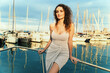 Stylish woman - posing on yacht with a marina backdrop, wearing a chic summer dress - elegance, leisure, fashionable.