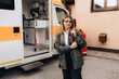 Happy paramedical professional standing near an ambulance
