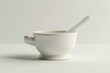 A simple white cup with a spoon inside. Suitable for various kitchen or dining concepts