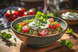 Quinoa salad with tomatoes, fresh herbs and sour creme in a bowl on the wooden kitchen table.
