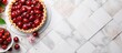 A delicious cherry pie and plates of sliced pieces showcased on a white tile background creating a copy space image
