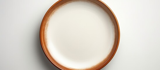 A ceramic plate with a brown circle set on a white background is devoid of any objects with additional space for text or images