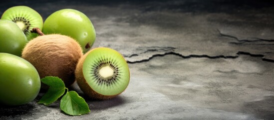 A copy space image showing kiwi fruits placed on a textured stone background