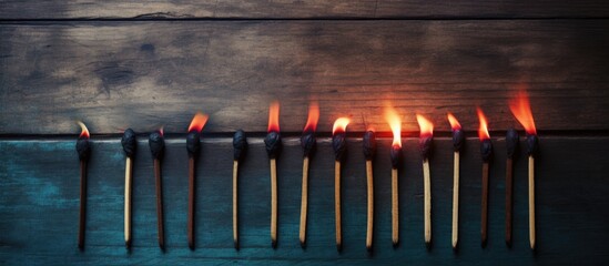 Poster - A burnt match in a row of matches on a wooden background allowing for copy space image