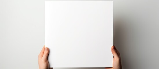 Poster - A copy space image of a white background featuring a person holding a blank notebook
