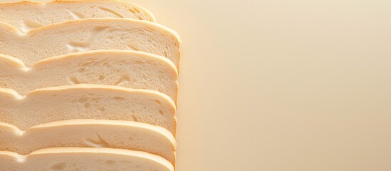 Poster - A close up top view of a beautiful big sliced bread on a cream color background perfect for design with copy space image
