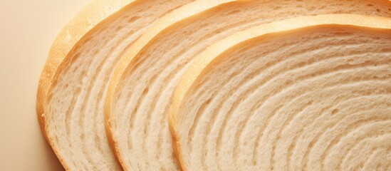 Poster - A close up top view of a beautiful big sliced bread on a cream color background perfect for design with copy space image