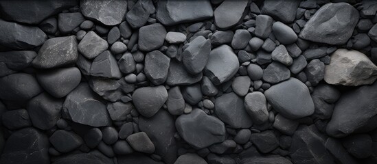 Poster - A dark background made of concrete adorned with stones creating an interesting and textured copy space image