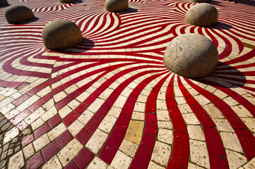 Poster - AI generated illustration of vibrant red and white patterned floor with round rocks