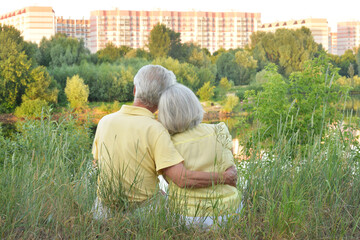 Wall Mural - Portrait of happy senior couple near lake during sunset at summer