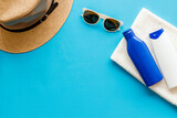 Fototapeta Mapy - Summer holiday beach background. Male straw hat with sunscreen and sunglasses, top view