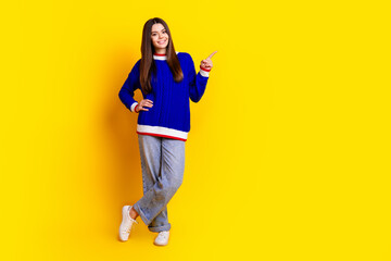 Poster - Full length photo of pretty teen girl point empty space wear trendy knitwear blue outfit isolated on yellow color background