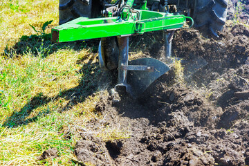 Wall Mural - Tractor plows field cultivates soil for spring planting of grain