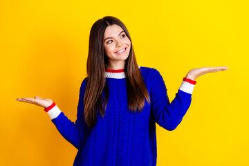 Sticker - Photo portrait of pretty teen girl hold look compare empty space wear trendy knitwear blue outfit isolated on yellow color background