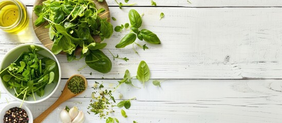 Wall Mural - Fresh green salad ingredients suitable for spring season and kitchen utensils on a white wooden surface, seen from above with space for text.