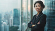 copy space, stockphoto, portrait of a senior asian business woman in a modern office on a high floor in a skyscraper, overlooking the city. Female Asian succesful businesswoman in a skyscraper.
