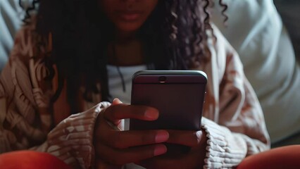 A woman holds a smartphone in her hands and presses the buttons