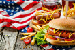 Picnic table with delicious food, burgers, french fries and condiments for USA 4th July Independence day