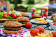 Picnic table with delicious food, burgers, french fries and condiments for USA 4th July Independence day