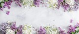 Arrangement of flowers with lilac and white flowers forming the border. Viewed from above with space for text.