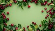 Fresh red cherries with green leaves arranged on a bright green background with copy space.