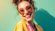 © Studio Zenith - Femme souriante avec des lunettes de soleil et vêtements d'été sur fond vert pastel