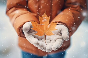 Child holding a maple leaf, snowy park background, playful winter day, closeup