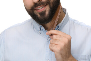 Sticker - Handsome young man combing beard on white background, closeup