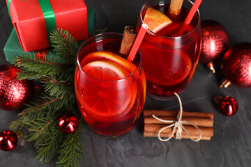 Wall Mural - Delicious Sangria drink in glasses and Christmas decorations on dark textured table, closeup