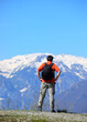 hiker with black backpack on shoulders before the big trek towards snow-capped mountains