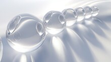 A Series Of Transparent Glass Orbs, Each Catching And Refracting Light In A Unique Way, Arranged In A Gentle Arc Against A Smooth, Light Silver Background.