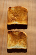 One pair of fried toast  lies on an oak board.