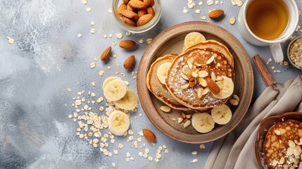 Healthy breakfast, oat pancakes with banana and almonds on a gray background, flat lay